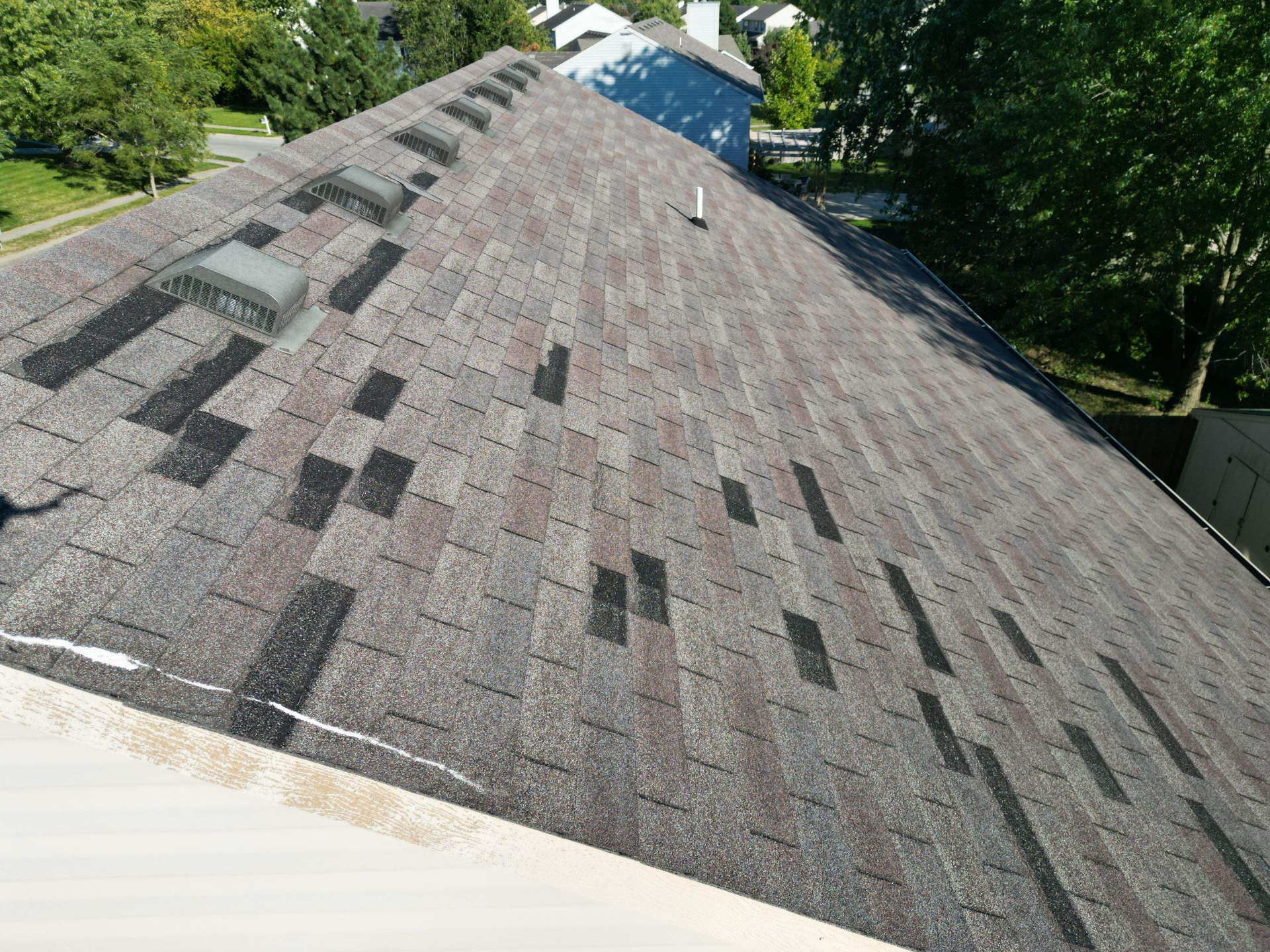 Aerial view of a worn 20-year-old shingle roof